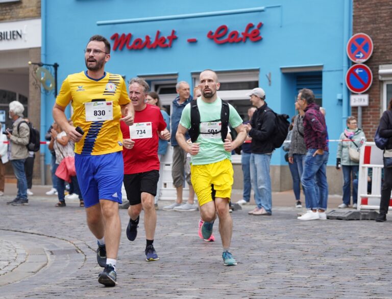 Bunte Laufshirts vor dem blauen Markt-Café
