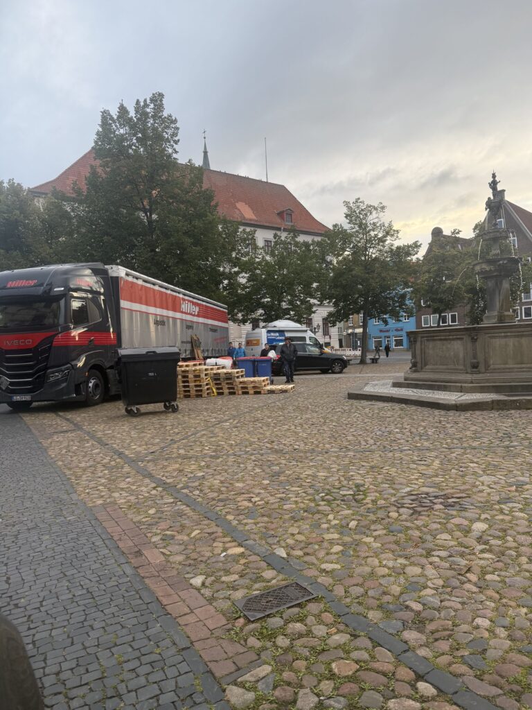 Früh am Morgen: Ein Lkw von Hiller Spedition & Logistik wird auf dem Marktplatz entladen, daneben der Luna-Brunnen