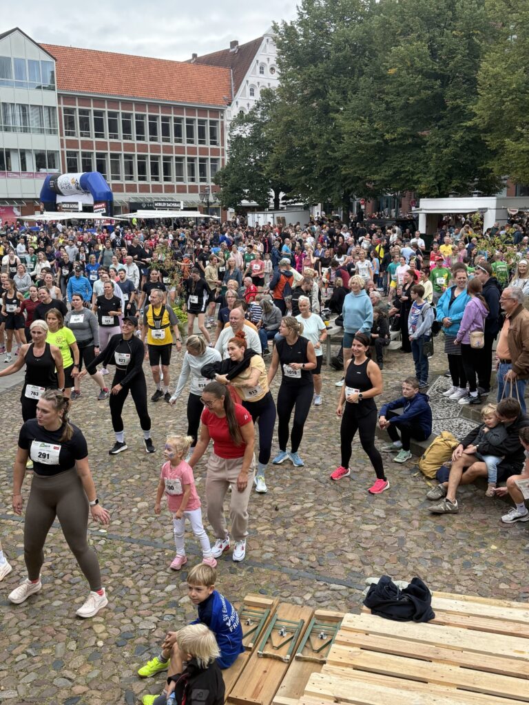 Aufwärmen auf dem Kopfsteinpflaster: Groß und Klein machen die Übungen mit